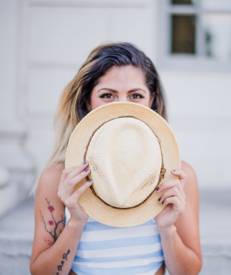 portrait of woman with hat in fron of her face