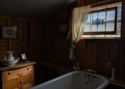 vintage clawfoot bathtub with stained glass window
