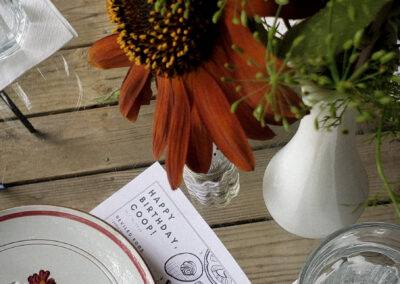 Flowers from the farm centerpiece surrounded by vintage table setting and custom menu designed in-house