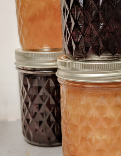 Four jars of different homemade jams (peach and blackberry)